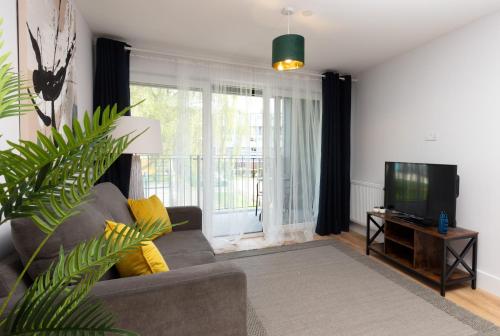 a living room with a couch and a television at Deluxe South Central Apartment in London