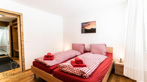 a bed with red slippers on it in a room at Haus Golmenegg, Riederalp in Riederalp
