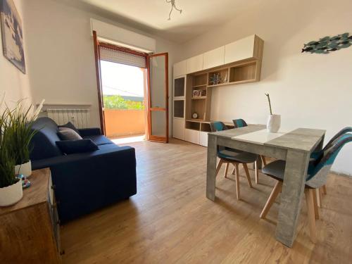 - un salon avec une table et un canapé bleu dans l'établissement Moderna Casa Fronte Mare, à Cogoleto