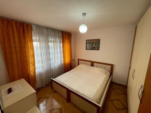 a small bedroom with a bed and a window at Brami Apartment in Berat