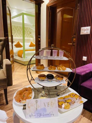 a display of pastries and desserts on a table in a room at Victorian Elegance Luxury Stays in Amritsar
