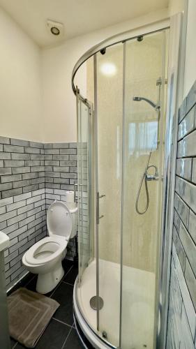 a bathroom with a toilet and a glass shower at Guest&Rest 11 in London