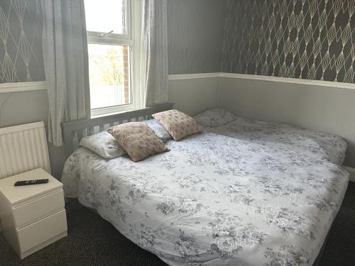 1 dormitorio con 1 cama con 2 almohadas y ventana en The Majestic, en Great Yarmouth