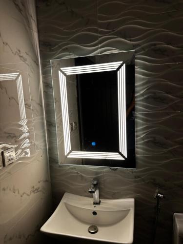 a bathroom with a white sink and a mirror at شقة انيقة بحي المنار in Jeddah