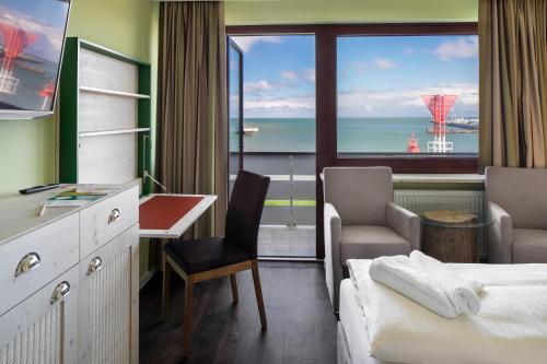 黑爾戈蘭島的住宿－Insulaner Dependance，配有一张床、一张书桌和一扇窗户的酒店客房