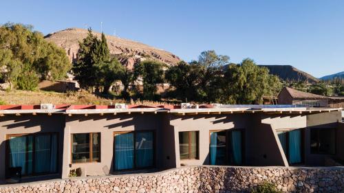 a house in front of a rock wall at Las Terrazas Hotel Boutique in Tilcara