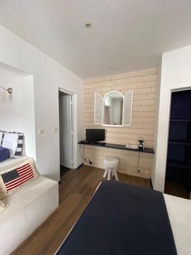 1 dormitorio con cama y escritorio con espejo en La Villa du Grand Large, en Biscarrosse