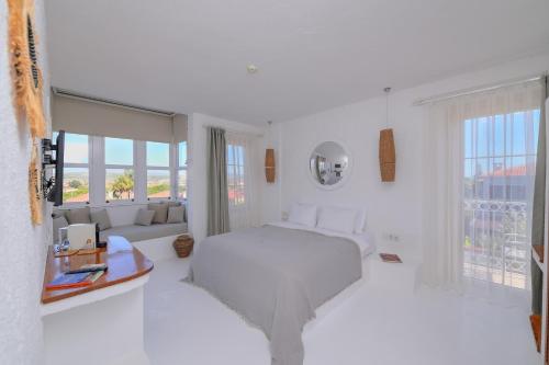 biała sypialnia z białym łóżkiem i oknami w obiekcie Peremere Alacati Otel w mieście Alaçatı