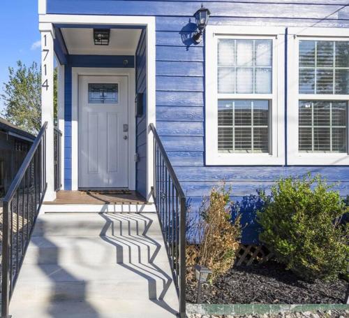 a blue house with a white door and stairs at Winter Retreat 3b 3ba Huge backyard Mins from Downtown in Houston