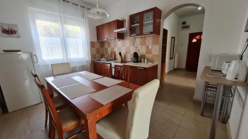 cocina con mesa de madera y comedor en Dunakeszi Nap Apartman, en Dunakeszi