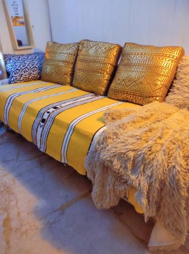 - un canapé jaune avec une couverture dans l'établissement SINGLE STUDIO QuartierLatin, à Paris