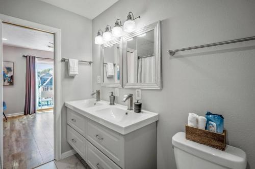 a white bathroom with a sink and a toilet at Winter Retreat 3b 3ba Huge backyard Mins from Downtown in Houston