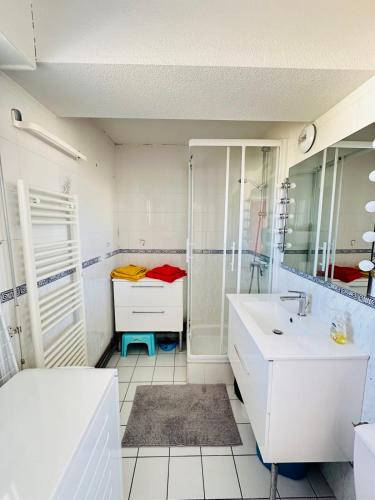 a white bathroom with a shower and a sink at Feet in the water breathtaking 180 sea view! in Port-Louis