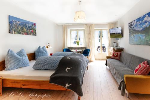 a living room with a bed and a couch at Pension Karner in Mittenwald