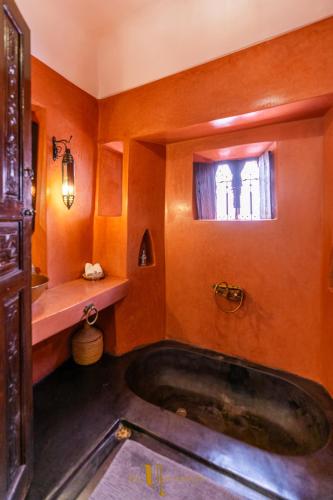 a bathroom with a tub and a window at Riad El Youssoufi in Marrakech