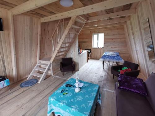una sala de estar con una escalera en una cabaña de madera en Cloudtop hut, en Gomi