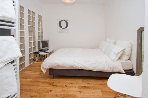 a white bedroom with a bed and a desk at Paris Les Halles in Paris