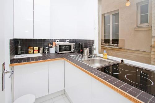 une cuisine avec un évier et un micro-ondes dans l'établissement Paris Les Halles, à Paris