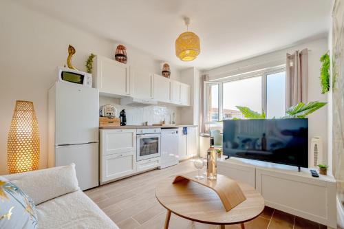 un salon avec un canapé, une télévision et une table dans l'établissement Wisdom Monkeys Apartment - Balcony & AC, à Toulon