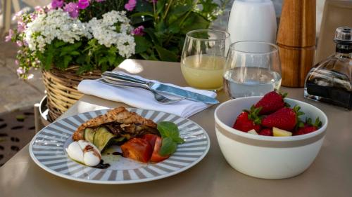 a table with a plate of food and a bowl of fruit at La Sommità Relais & Chateaux in Ostuni