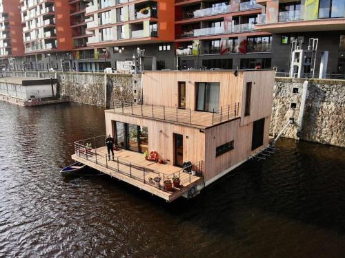 een woonboot in het water naast gebouwen bij One of the kind Prague Houseboat Experience +BOAT in Praag