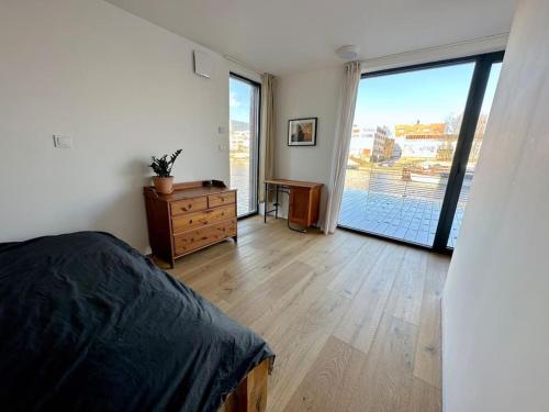 One of the kind Prague Houseboat Experience +BOAT في براغ: غرفة نوم بسرير وباب زجاجي منزلق كبير