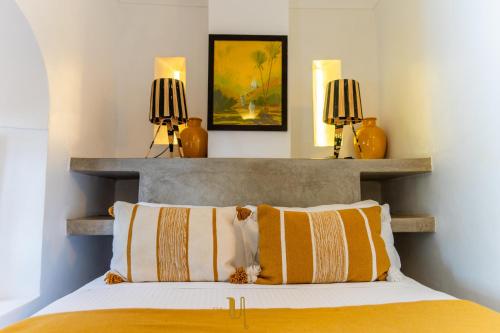 a bedroom with a bed with two lamps on the wall at Riad El Youssoufi in Marrakech