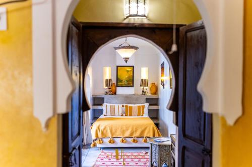 馬拉喀什的住宿－里亞德厄爾優素菲酒店，一间卧室设有一张床和一个拱形门廊