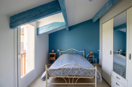 um quarto com uma cama e uma parede azul em Gîte Piscine et Jacuzzi intérieurs em Cherveix-Cubas