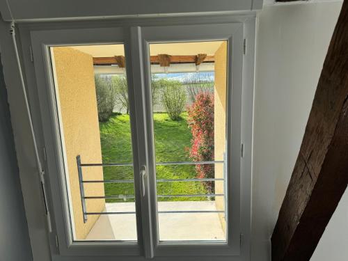 a window with a view of a garden outside at calme et verdure in La Bazouge-de-Chemeré