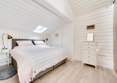 um quarto branco com uma cama e um tecto branco em The Artists Studio - Syderstone em Syderstone