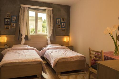 two beds in a room with a window at The Rolé House in Gurjaani