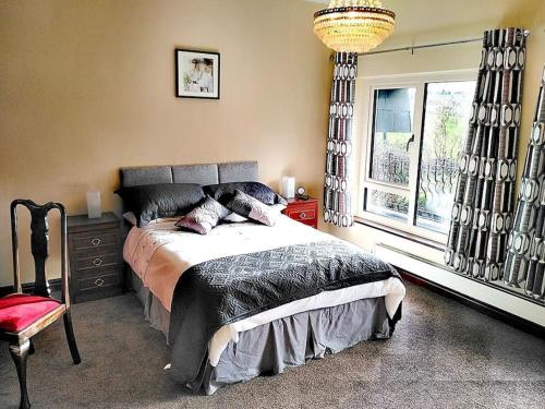 een slaapkamer met een bed, een raam en een stoel bij Annalee House, Knappagh Valley - 1 hour to Airport in Shercock