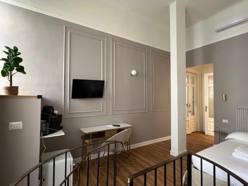 a living room with a bed and a tv on a wall at Turin Central Cavour in Turin
