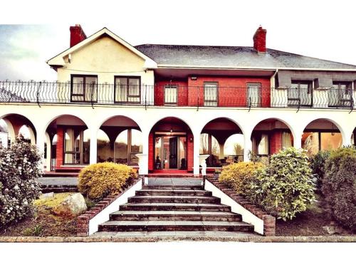 a large white house with stairs in front of it at Annalee House, Knappagh Valley - 1 hour to Airport in Shercock