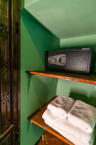 a shelf with towels on a green wall at Riad El Youssoufi in Marrakech