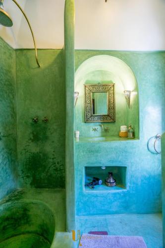 a blue bathroom with a sink and a mirror at Riad El Youssoufi in Marrakech