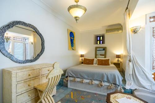 a bedroom with a bed and a mirror at Riad El Youssoufi in Marrakech