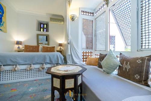 a living room with two beds and a table at Riad El Youssoufi in Marrakech