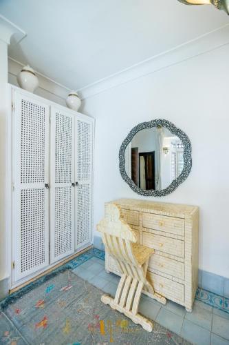 a mirror in a room with a bench and a table at Riad El Youssoufi in Marrakech