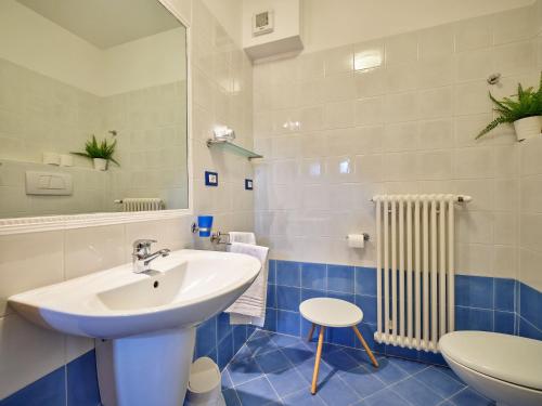ein Badezimmer mit einem Waschbecken, einem WC und einem Spiegel in der Unterkunft Appartamenti La Perla in Malcesine