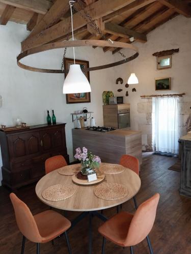 a kitchen and dining room with a table and chairs at Gite Les 3 Toitures Ecogite le Luquet Saint Beauzeil 82 in Saint-Beauzeil