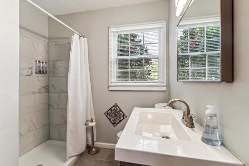 uma casa de banho branca com um lavatório e um chuveiro em Spacious 4BR Marietta Home, Perfect for Families em Marietta