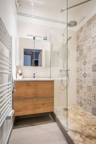 une salle de bain avec une douche, un lavabo et un miroir dans l'établissement Le Vintage, Beau T3, Clim, Terrasse, Centre ville, à Montpellier