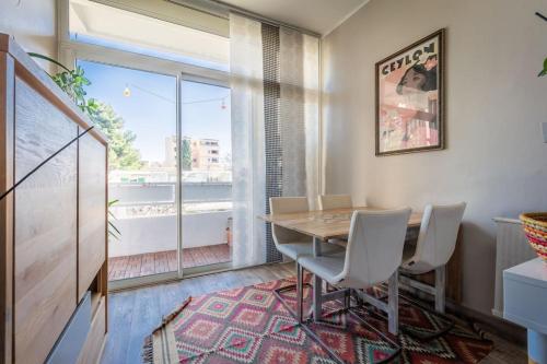 une salle à manger avec une table et des chaises et une grande fenêtre dans l'établissement Le Vintage, Beau T3, Clim, Terrasse, Centre ville, à Montpellier