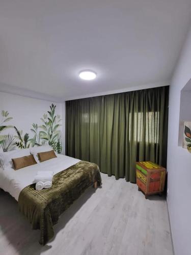 - une chambre avec un grand lit et des rideaux verts dans l'établissement Maison de charme à Vétraz-Monthoux - Terrasse, à Vétraz-Monthoux