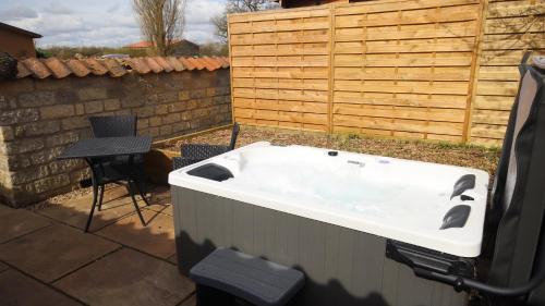 a bath tub in a backyard with a table and a chair at Barker Stakes Farm in Pickering