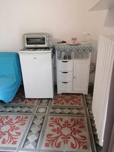 a small kitchen with a microwave and a refrigerator at Malvasia room in Brindisi