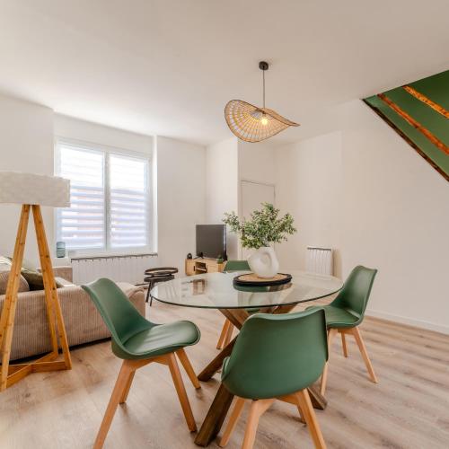 - un salon avec une table et des chaises vertes dans l'établissement Maison à Roubaix, à Roubaix