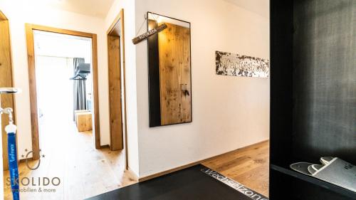 a hallway with a door and a mirror on a wall at Haus Golmenegg, Riederalp in Riederalp